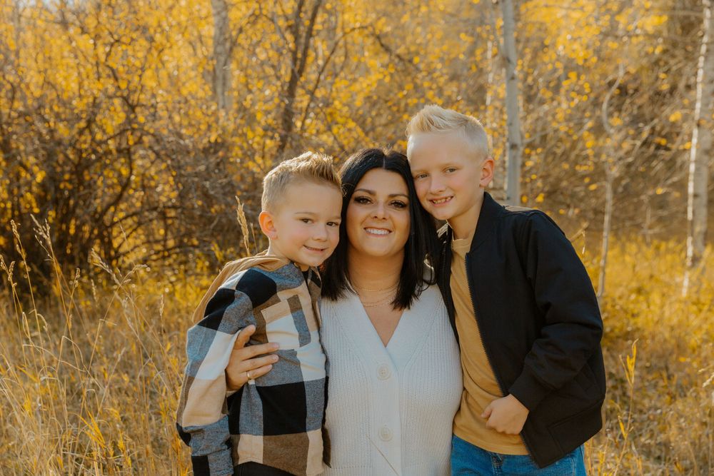 Family members posing together against a backdrop of golden aspen trees.