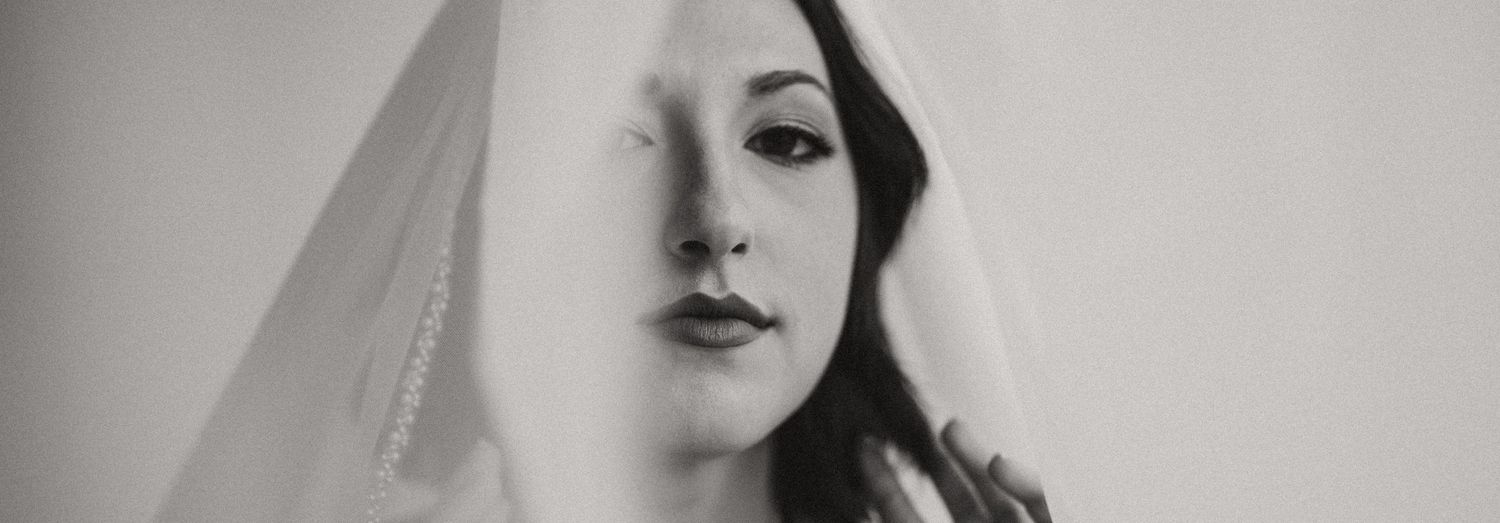A dramatic black and white bridal portrait featuring an elegant veil.