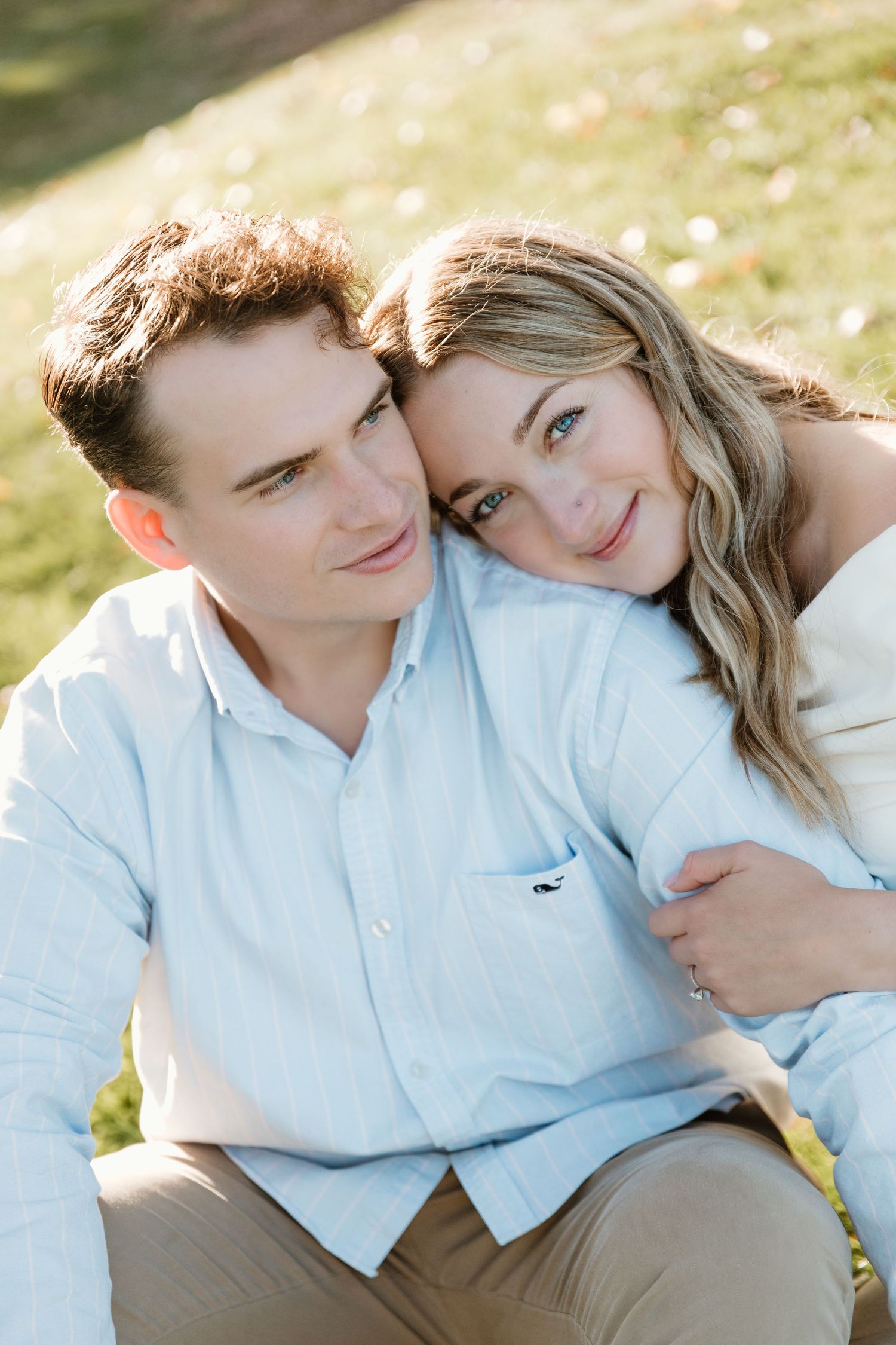 Couple in casual attire sharing an intimate moment outdoors in golden sunlight.