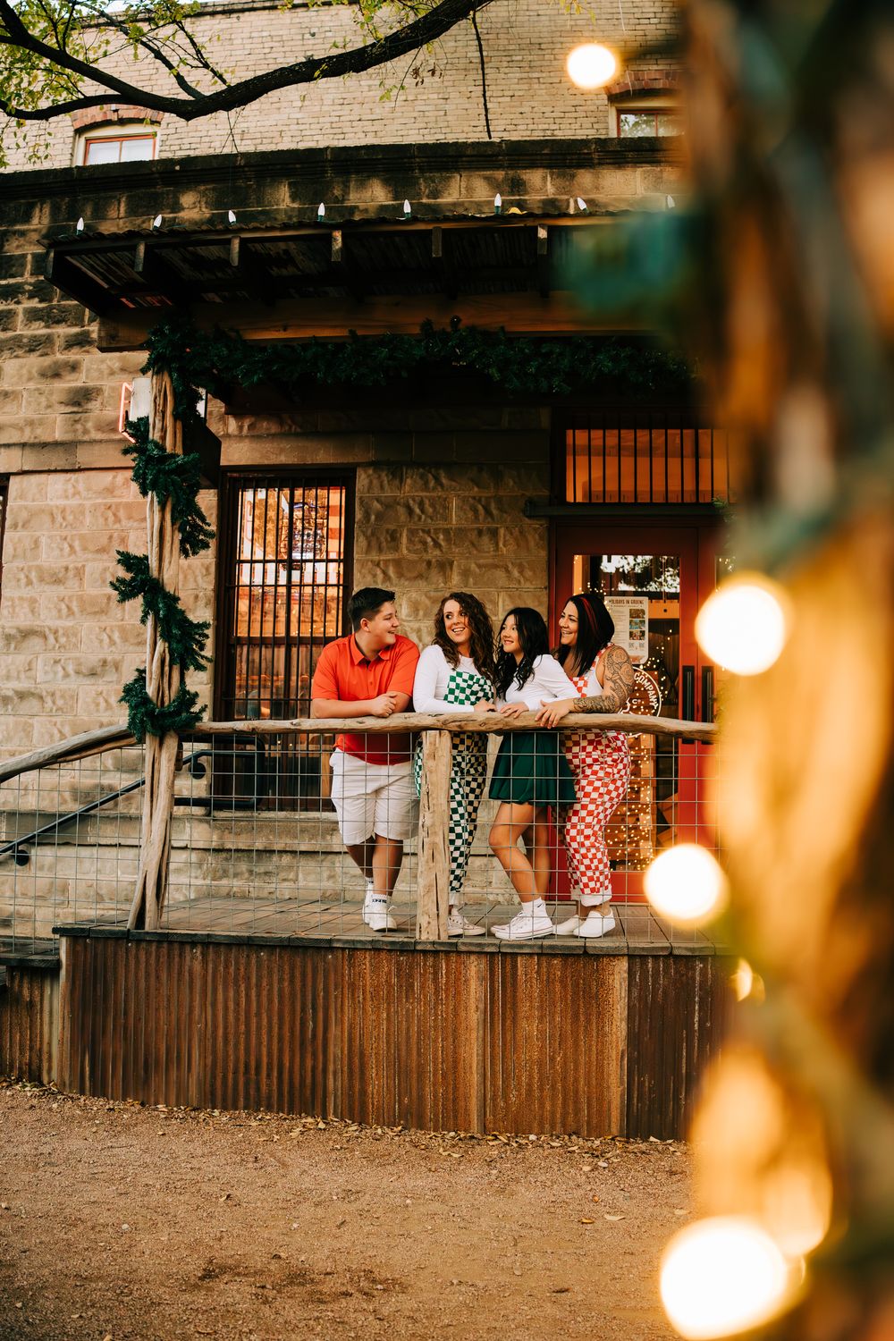 Family of 4 looking at each other on a deck in Gruene, Tx.