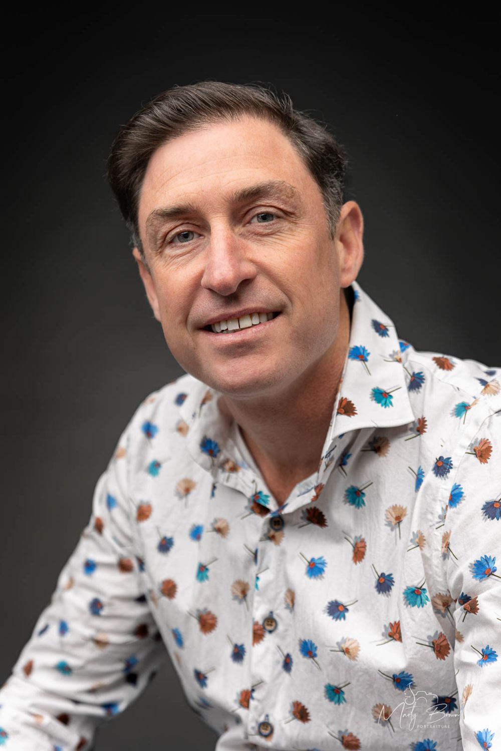 Corporate man in dress shirt sitting studio portrait