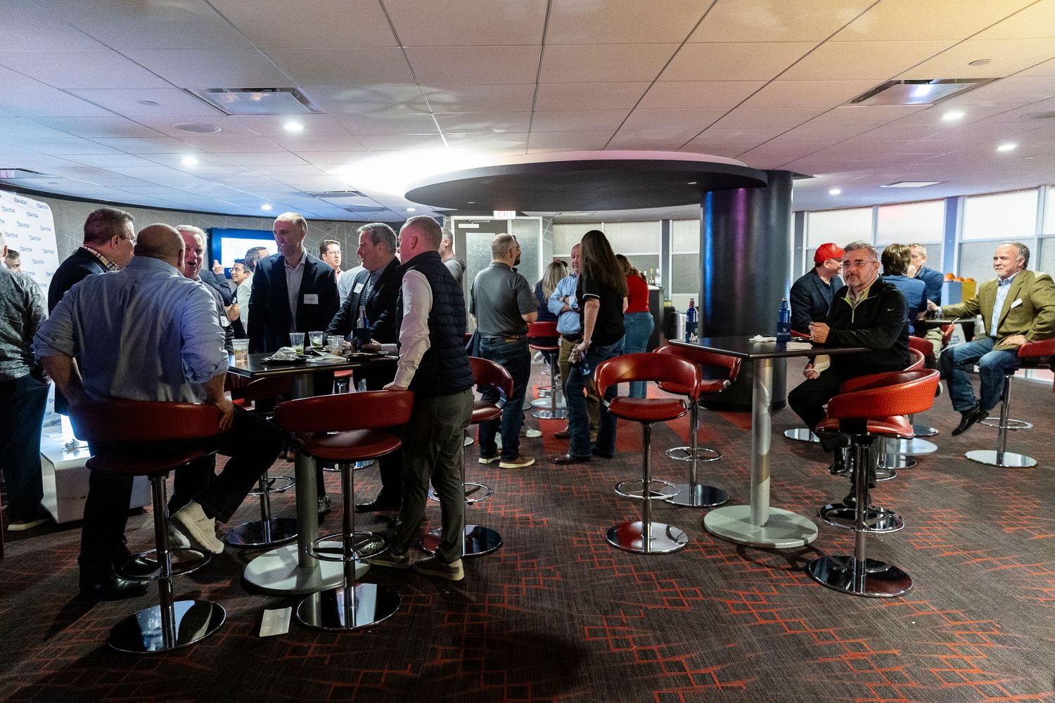 Audience members seated in stadium-style seating during an indoor event.