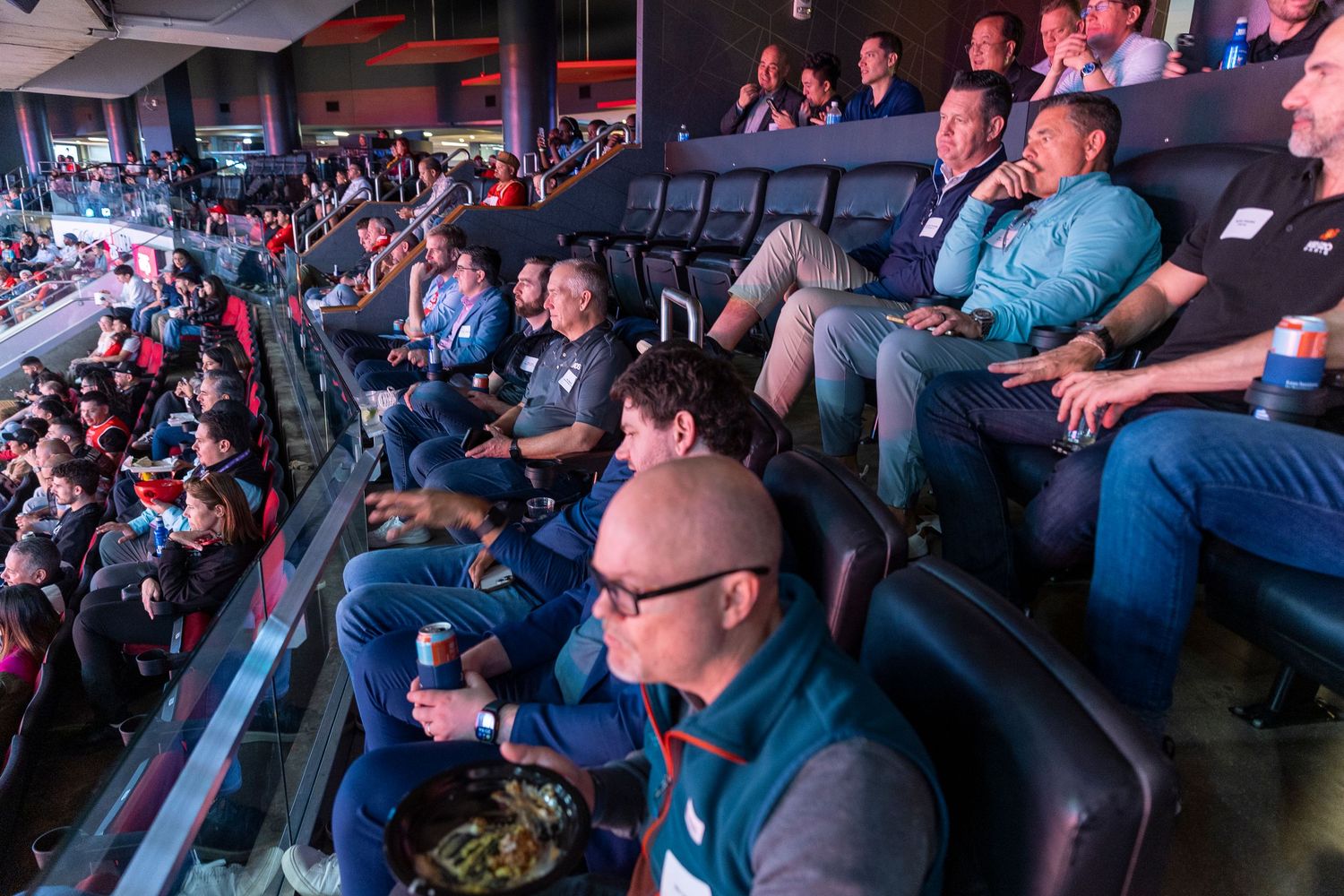 Spectators watching intently in tiered seating at an indoor venue.