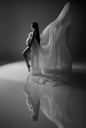 Artistic black and white portrait of a flowing white dress creating dramatic silhouettes.