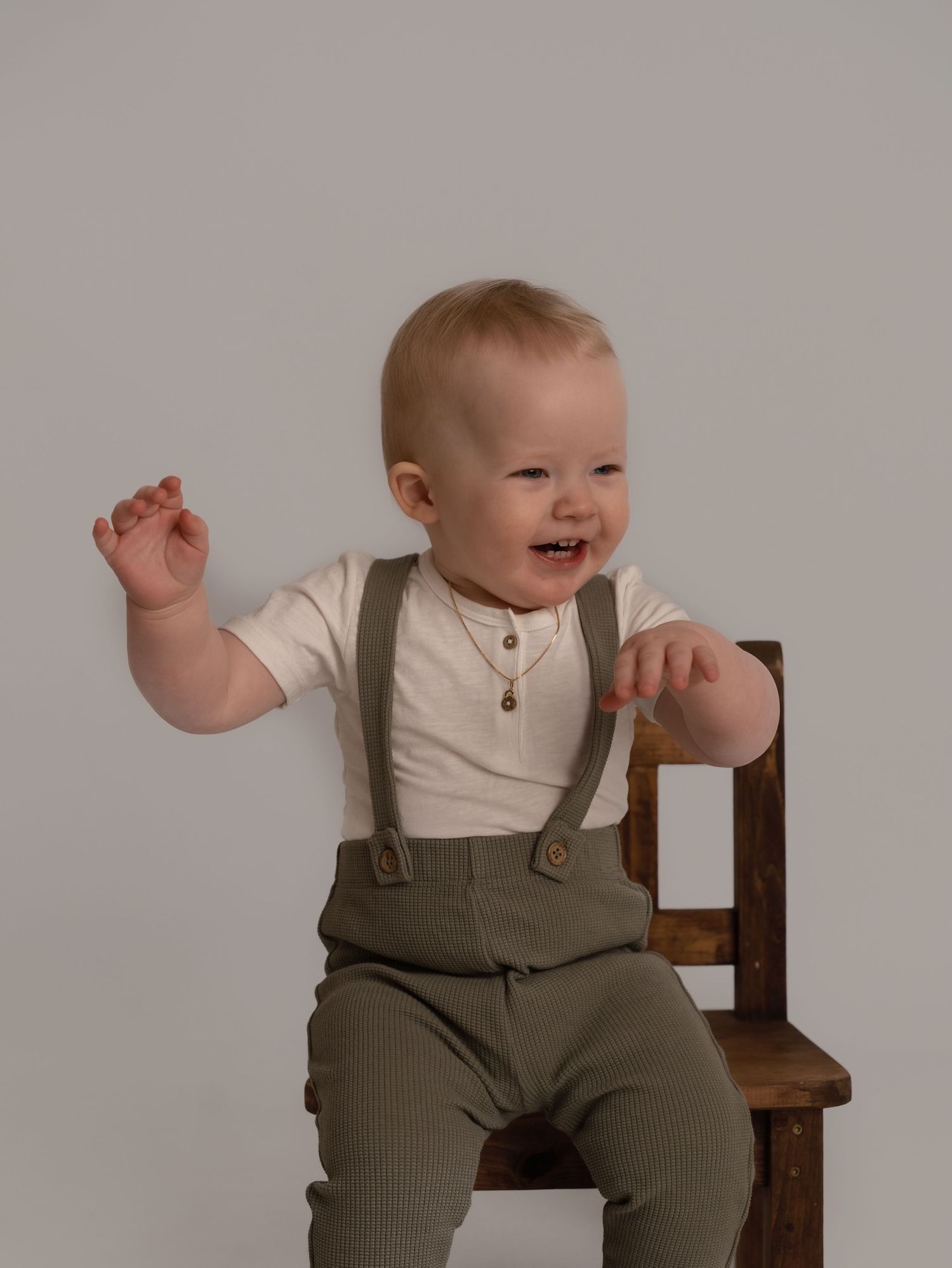 Ettårfotografi av smilende gutt på stol i studio Årdal i Ryfylke