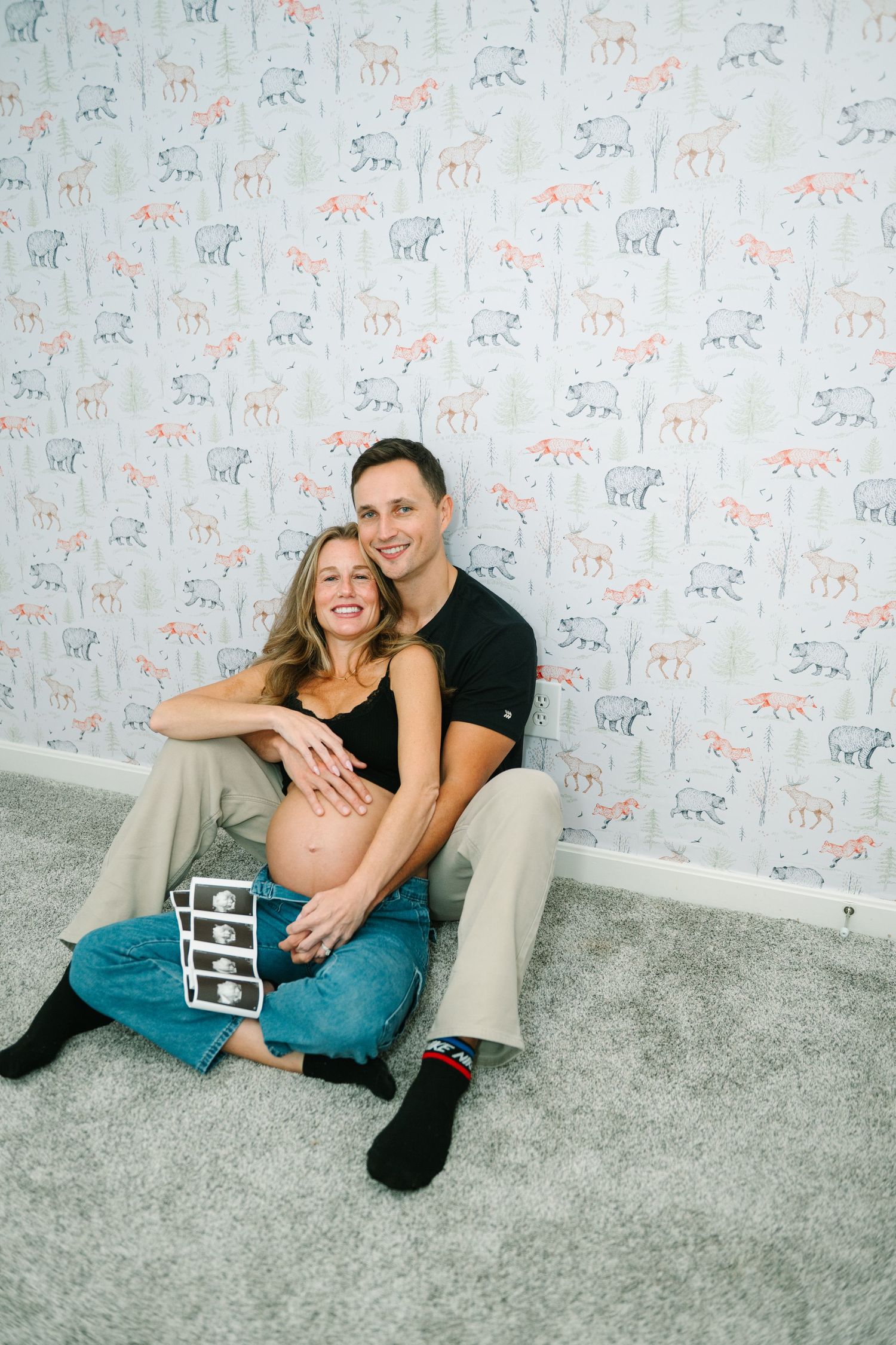 Two young children pose together against a pastel balloon backdrop for a sweet portrait session.