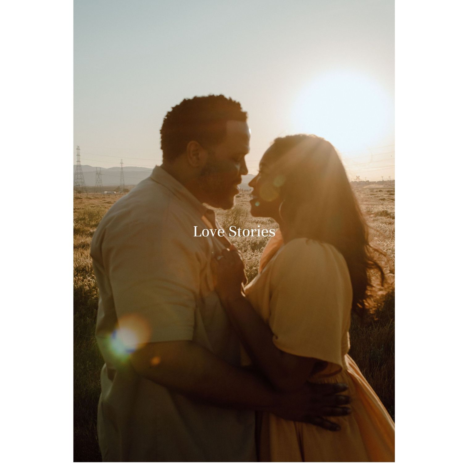 Couple embraces in warm sunset light with mountains in background creating romantic silhouette effect.