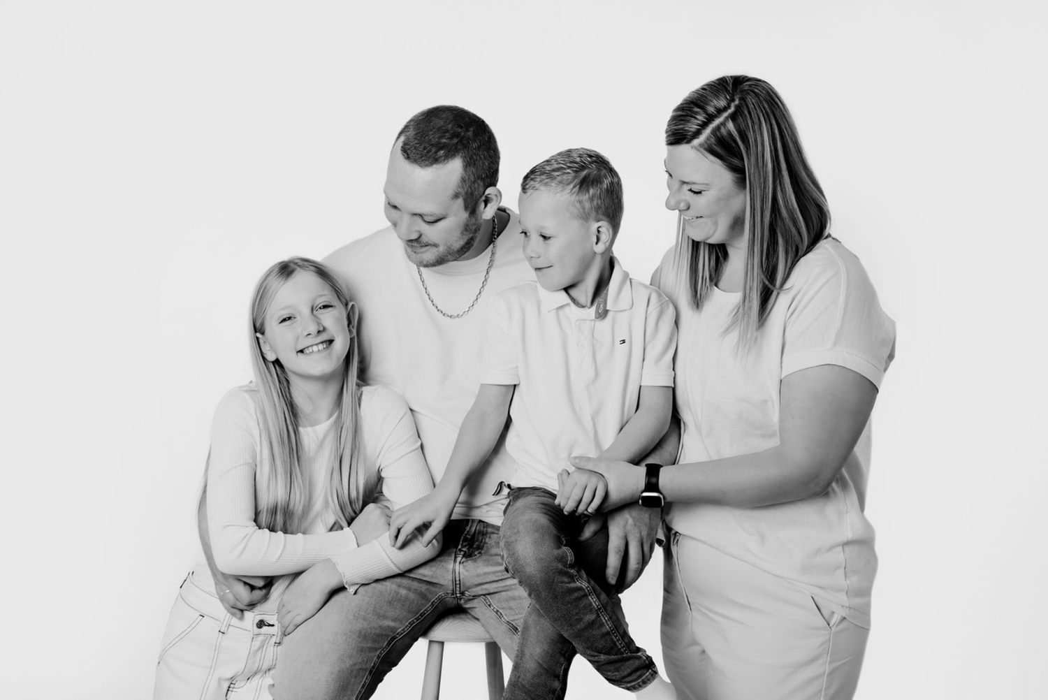 Familie, der deler et intimt øjeblik i et studio til en familiefotografering. Fotograf Middelfart