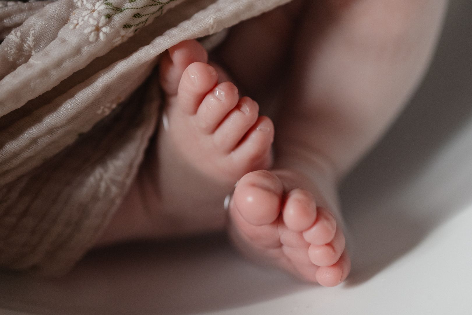 photo de pieds d'un nouveau-ne pendant son bain enveloppe a Lille durant un reportage naissance et TBB