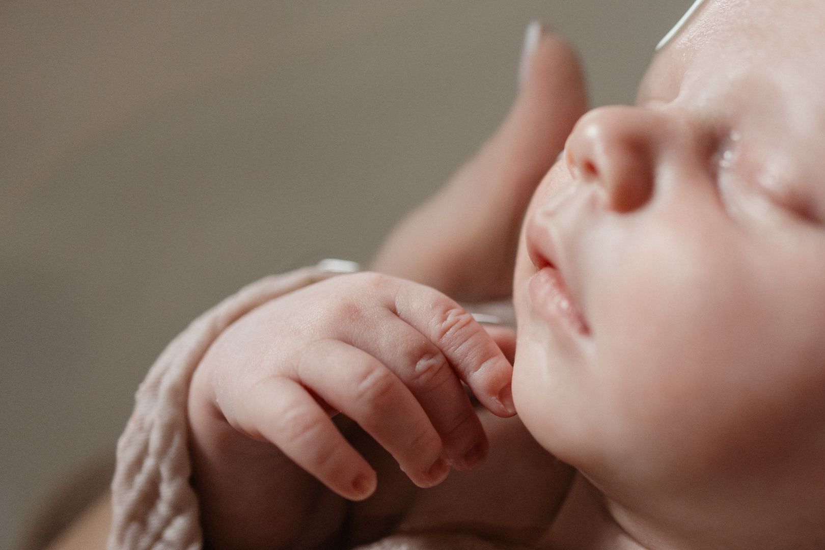 seance photo bain bebe Lille : details de main et visage d'un nouveau-ne en reportage naissance et TBB avec Manescance