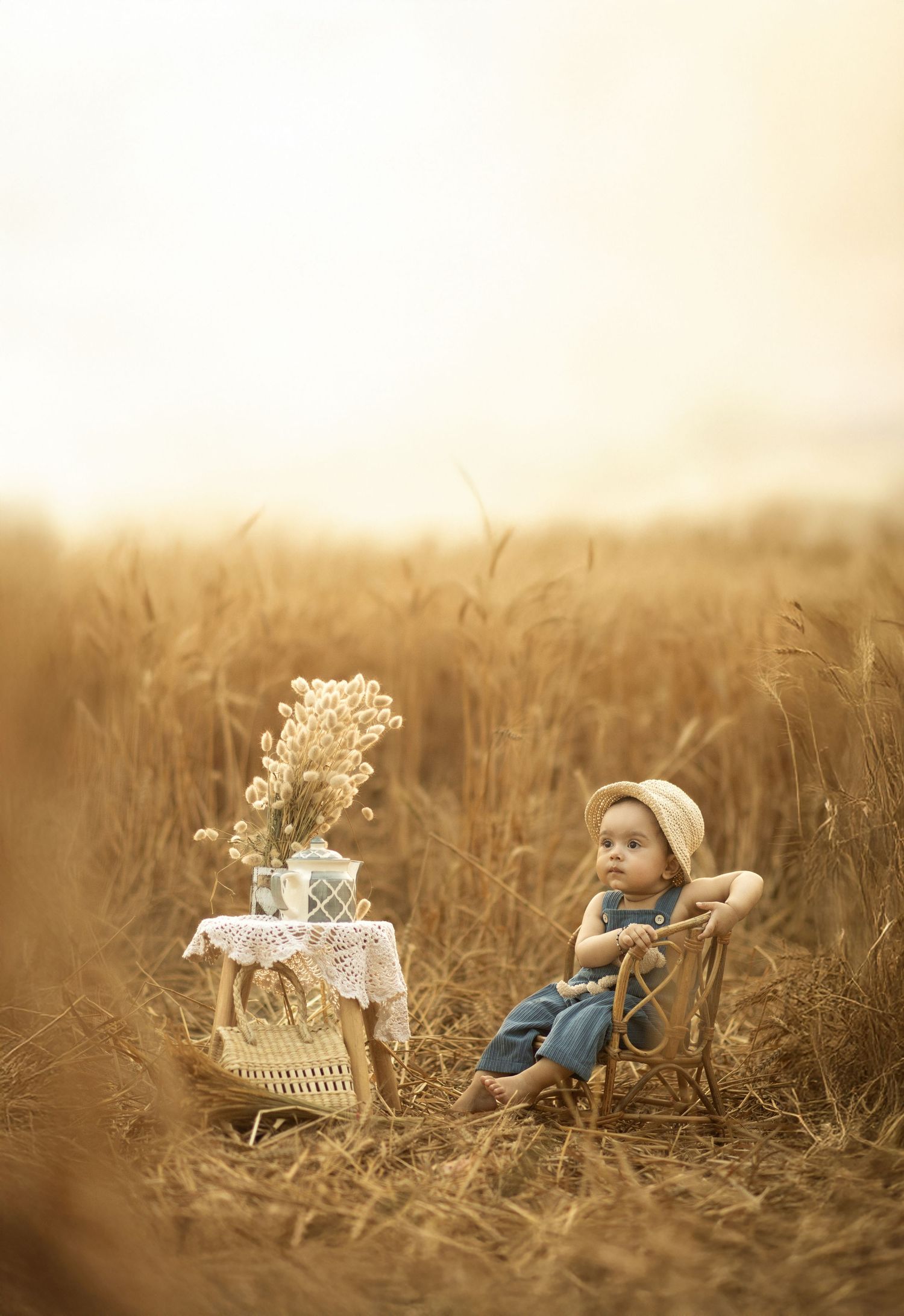 A dreamy sepia scene with a small chair and table setup among tall wheat stalks in a golden field.