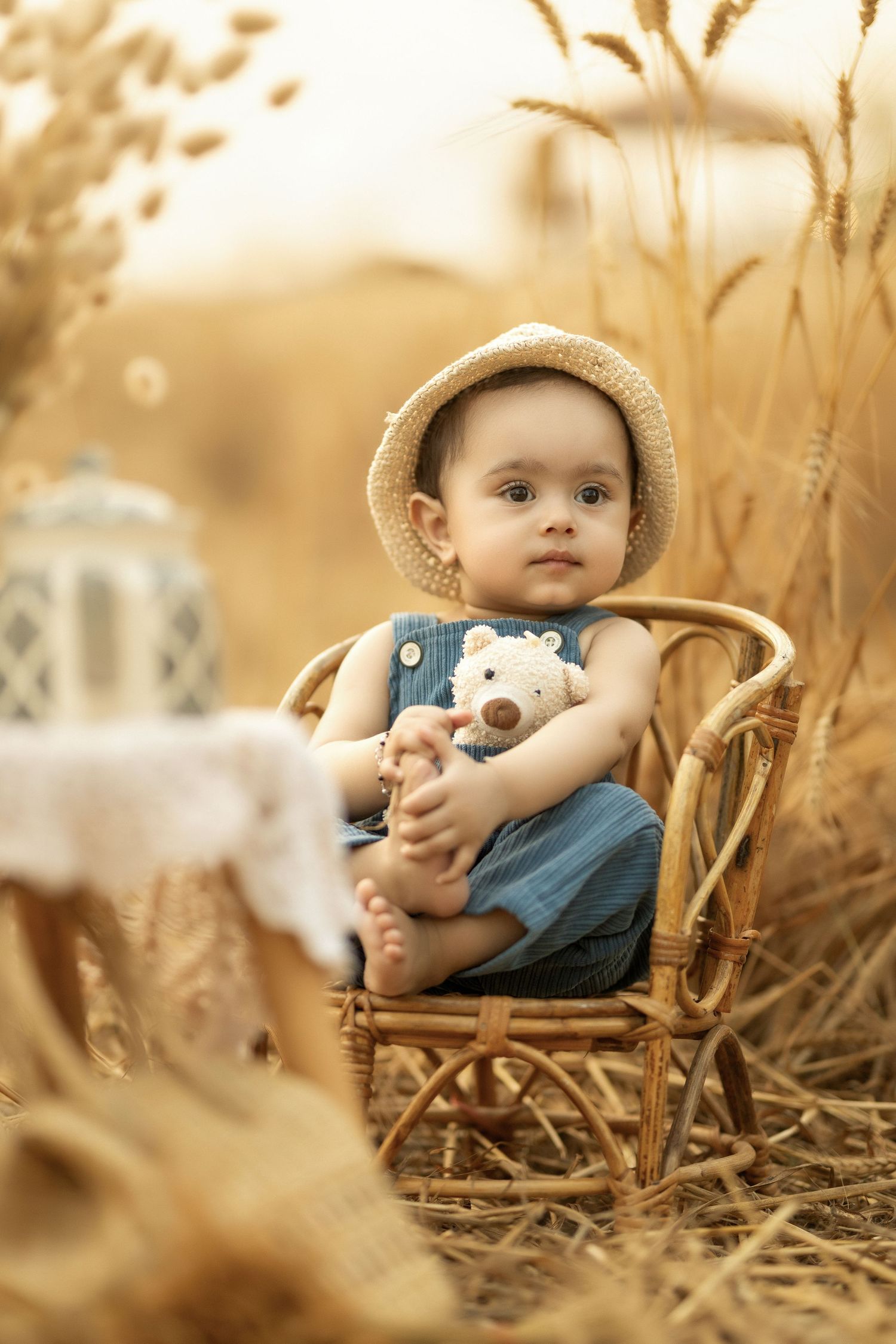 A vintage-toned photo of a tiny figure seated in a wicker chair amidst golden wheat stalks.