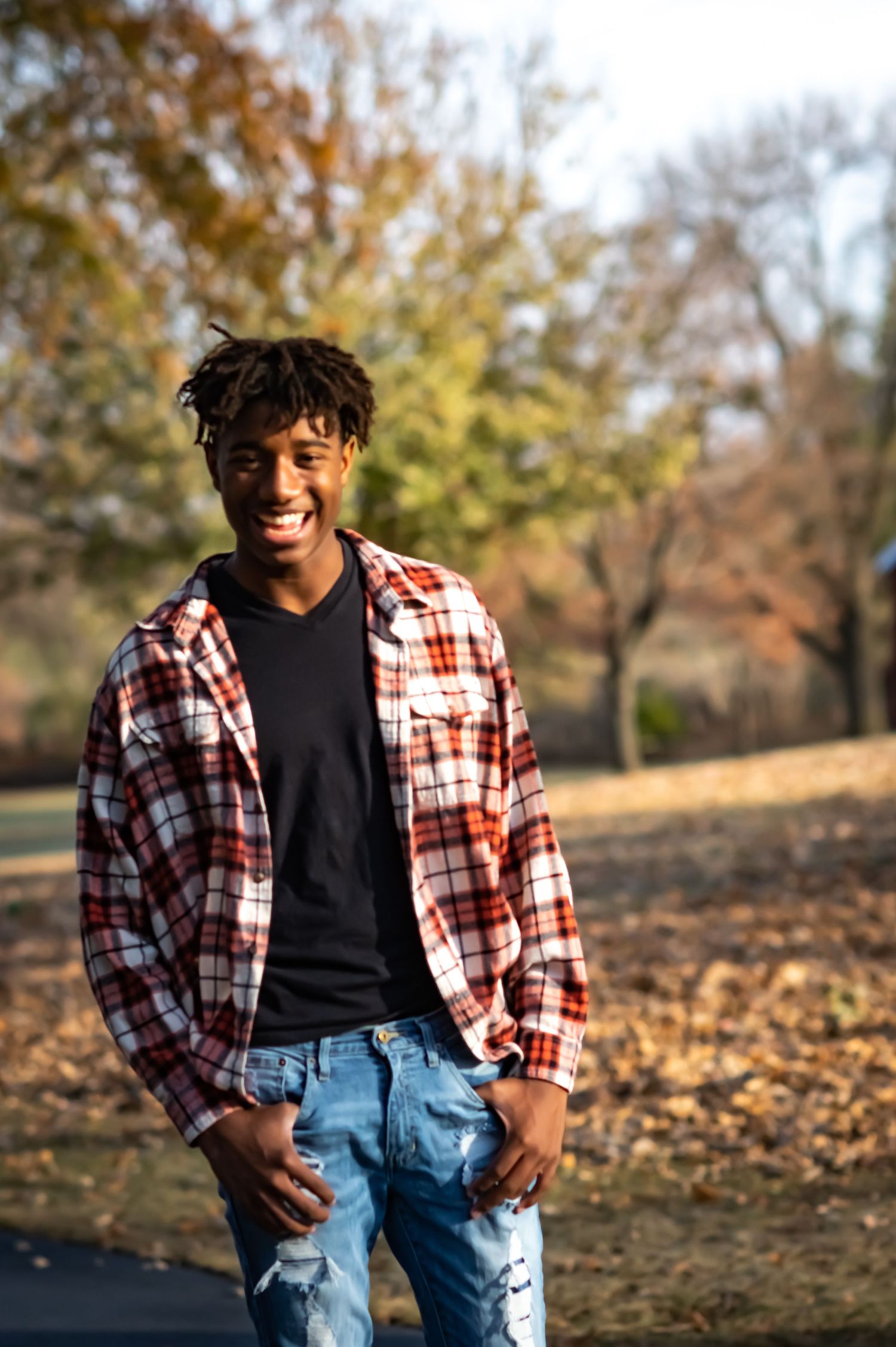 Portrait shot with blue sky background and white t-shirt showing artistic signature overlay.