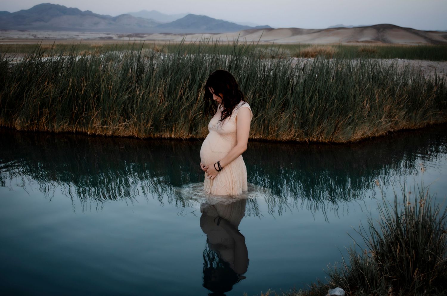 Scenic mountain landscape with wetlands of moody maternity photoshoot in Las Vegas. Moody maternity photoshoot on Las Vegas
