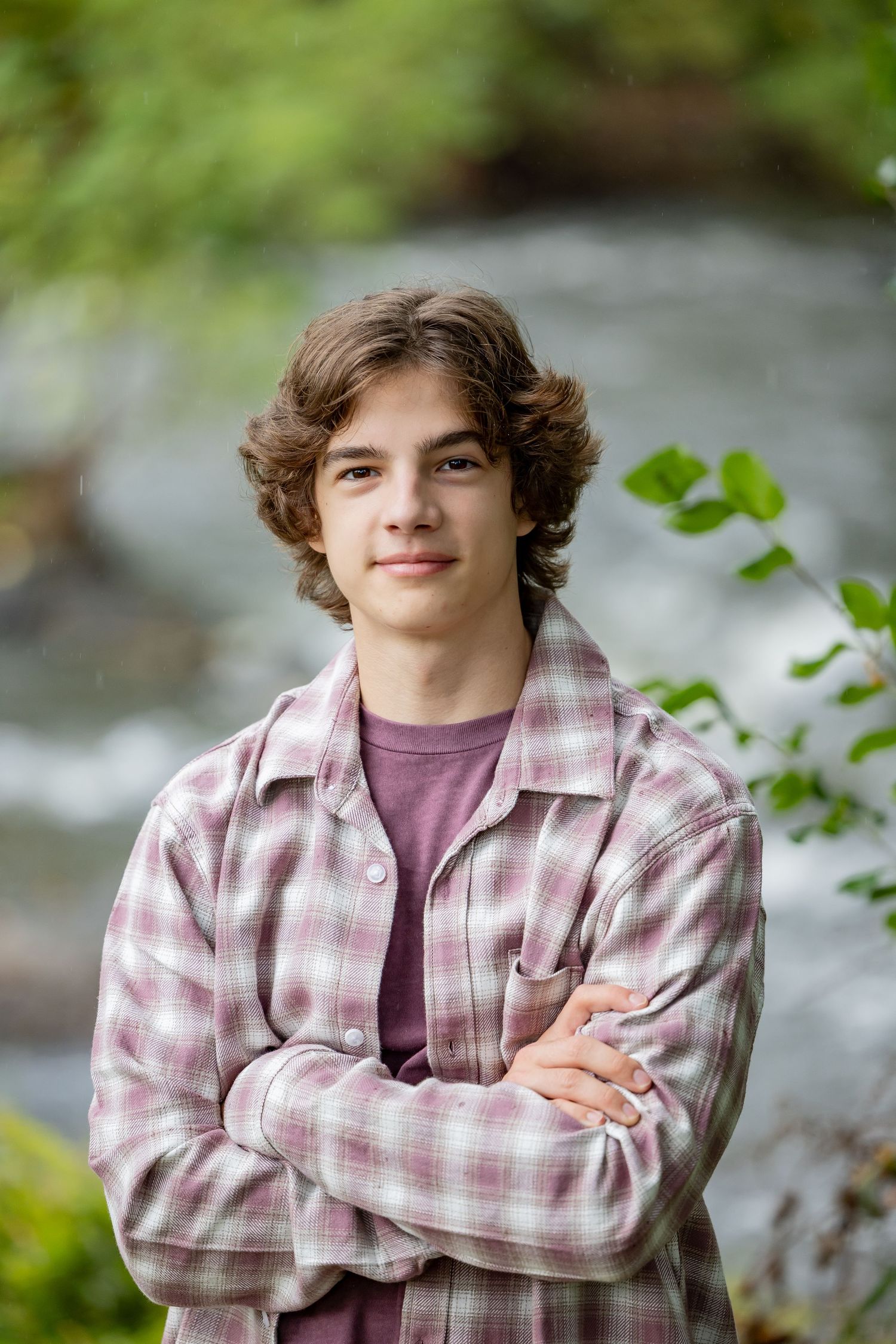Casual portrait in plaid flannel shirt against natural outdoor background.