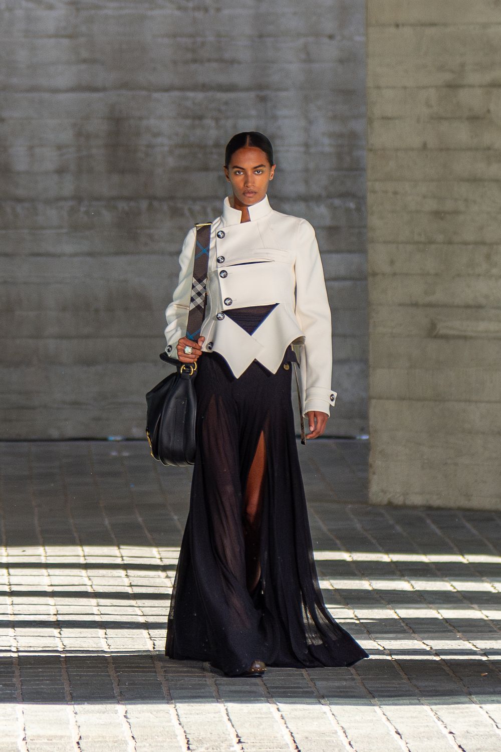 A female model in smart-casual clothing walks on a runway during the Burberry fashion show in London, UK.