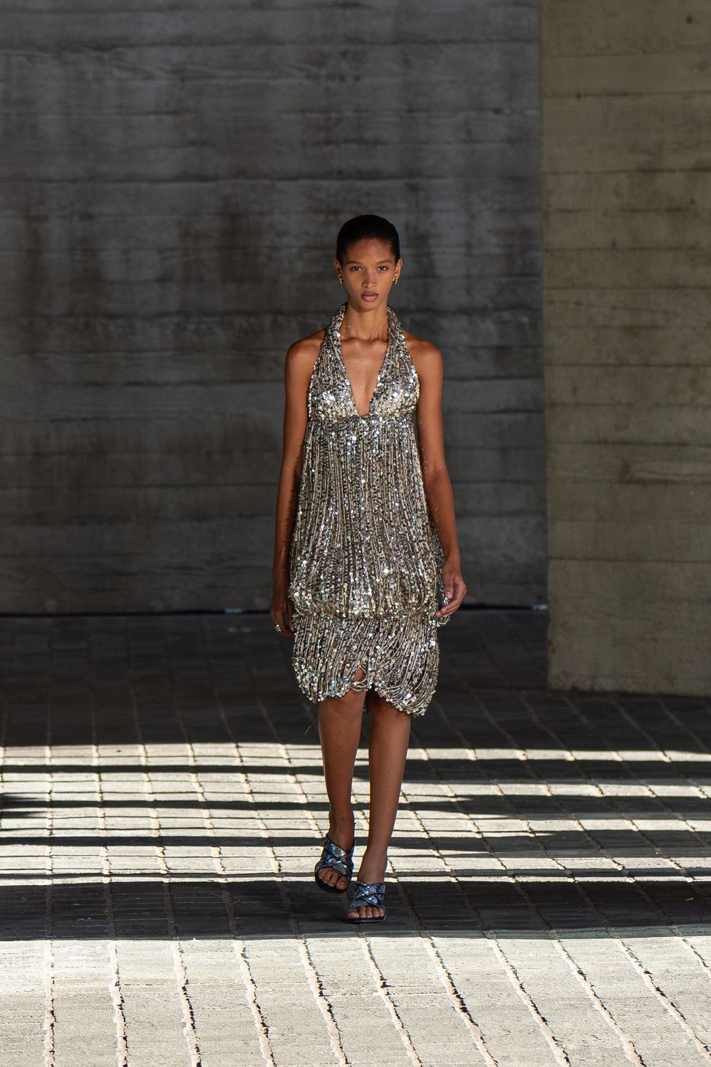 A model in a silver dress walks on a runway during the Burberry fashion show in London, UK.