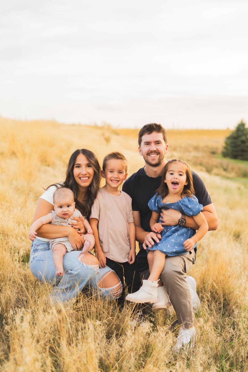 Candid family photos in a golden field during sunset showing joyful expressions.