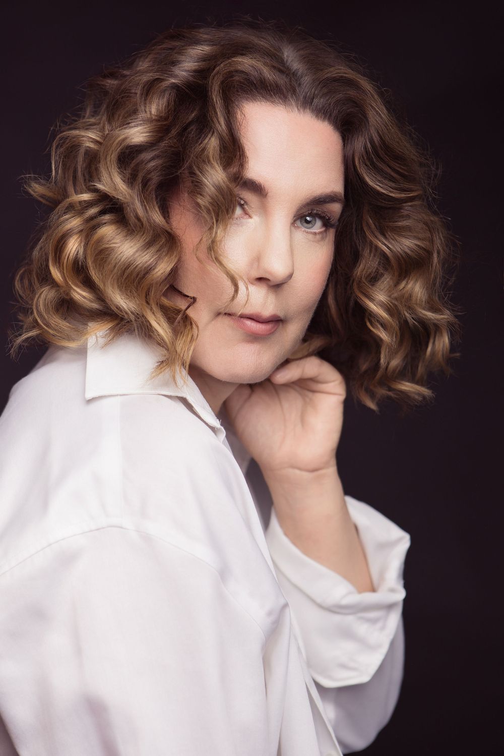 Artistic portrait series showing curly brown hair and white button-down shirt against dark background.