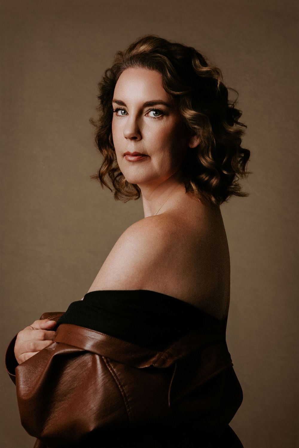 A series of sepia-toned artistic portraits showing dramatic poses in moody lighting against a neutral backdrop.