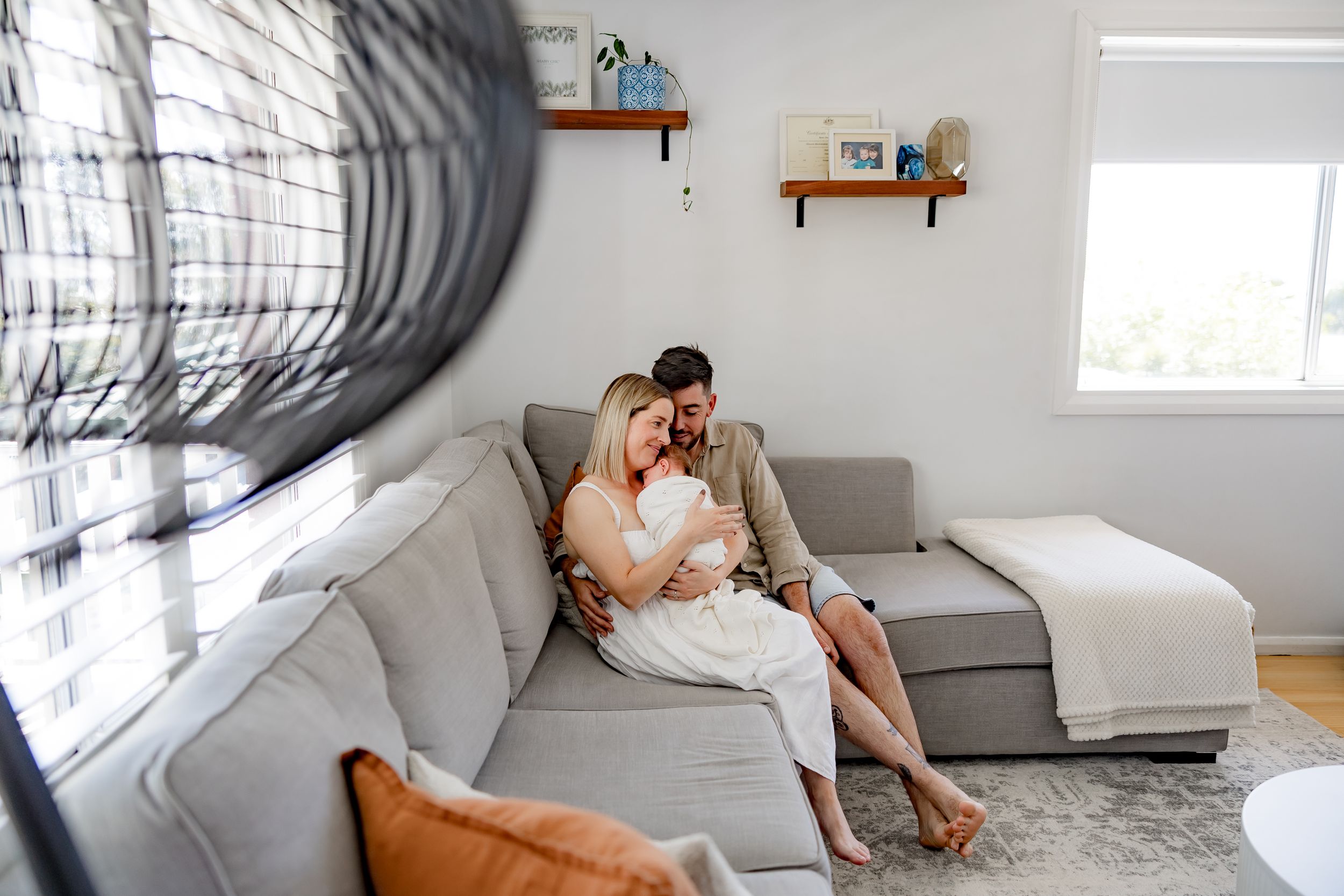 A couple relaxing together on a grey sectional sofa in a bright modern living room.