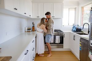 A bright modern white kitchen with hardwood floors and minimalist design.