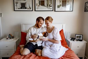 A series of four intimate moments captured on a couch showing a couple in white clothing with their cat.