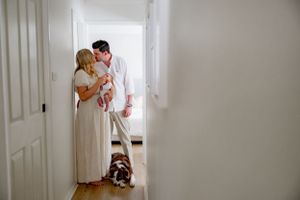 A hallway scene with a brown dog and family sharing an intimate moment.