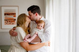 A bright, modern bedroom setting with a family sharing an intimate embrace.