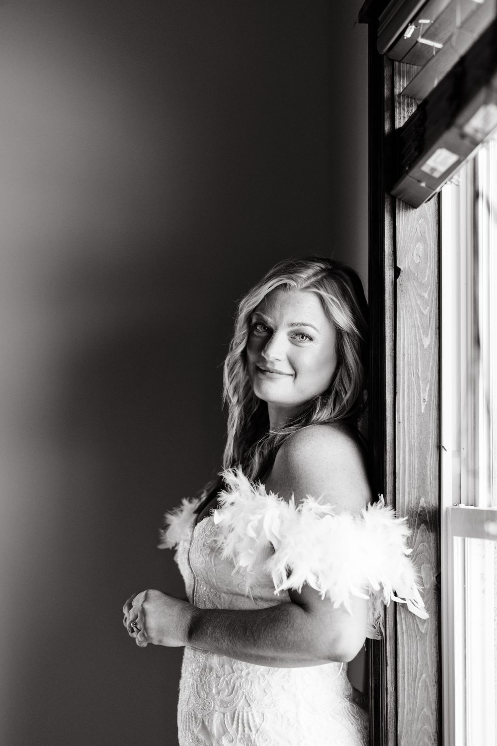 A black and white artistic photo sequence showing a person in white feathered clothing posing near a window.