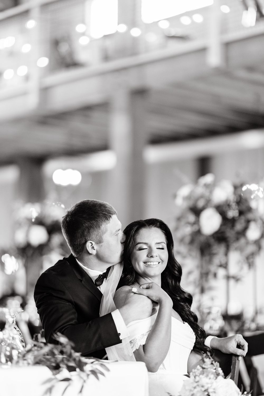 A sequence of candid black and white reception photos showing tender moments between a couple at their wedding celebration.