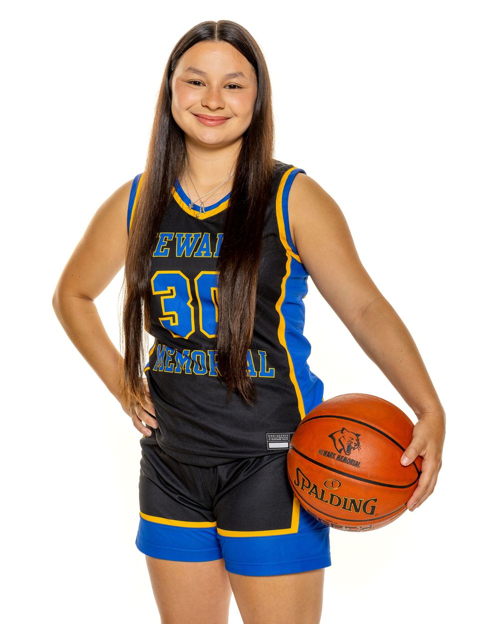 Basketball player in black and blue Newark Memorial jersey number 30 poses with Spalding ball.