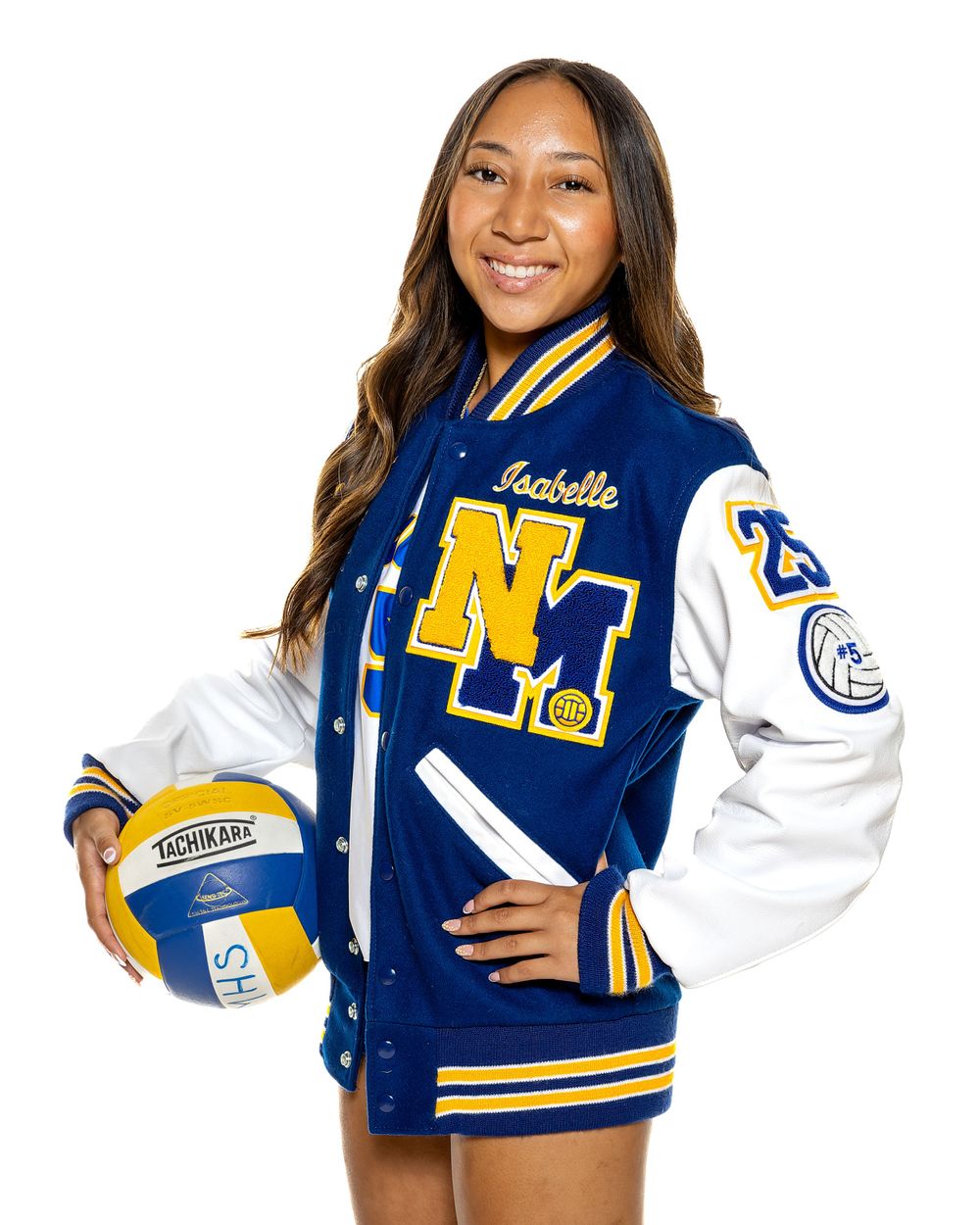 Volleyball player in varsity letterman jacket posing with ball.