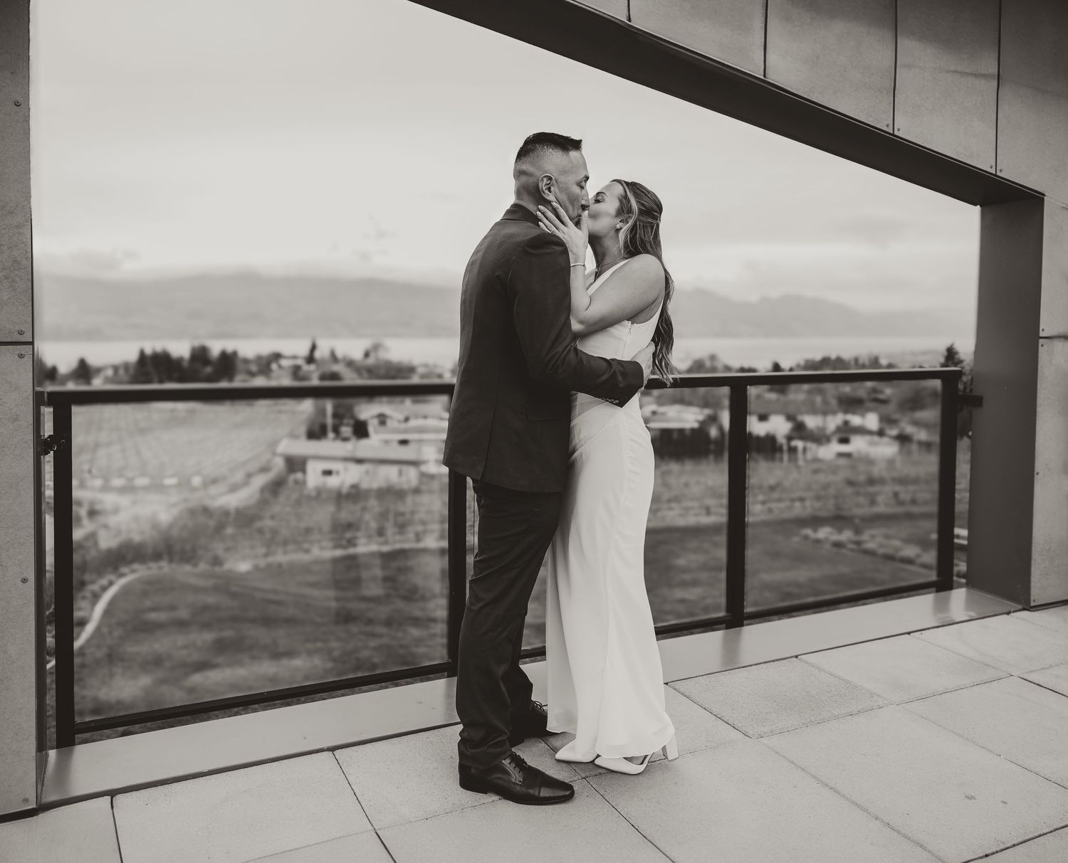 husband and wife smiling and laughing at one another at a couples photoshoot in kelowna bc