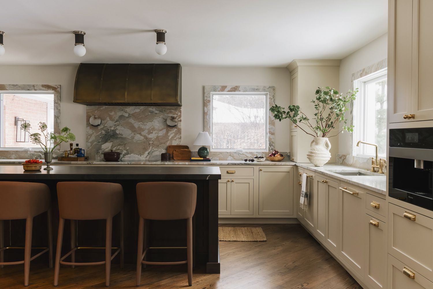 Traditional kitchen with beige cabinetry, warm wood island, and gold hardware.