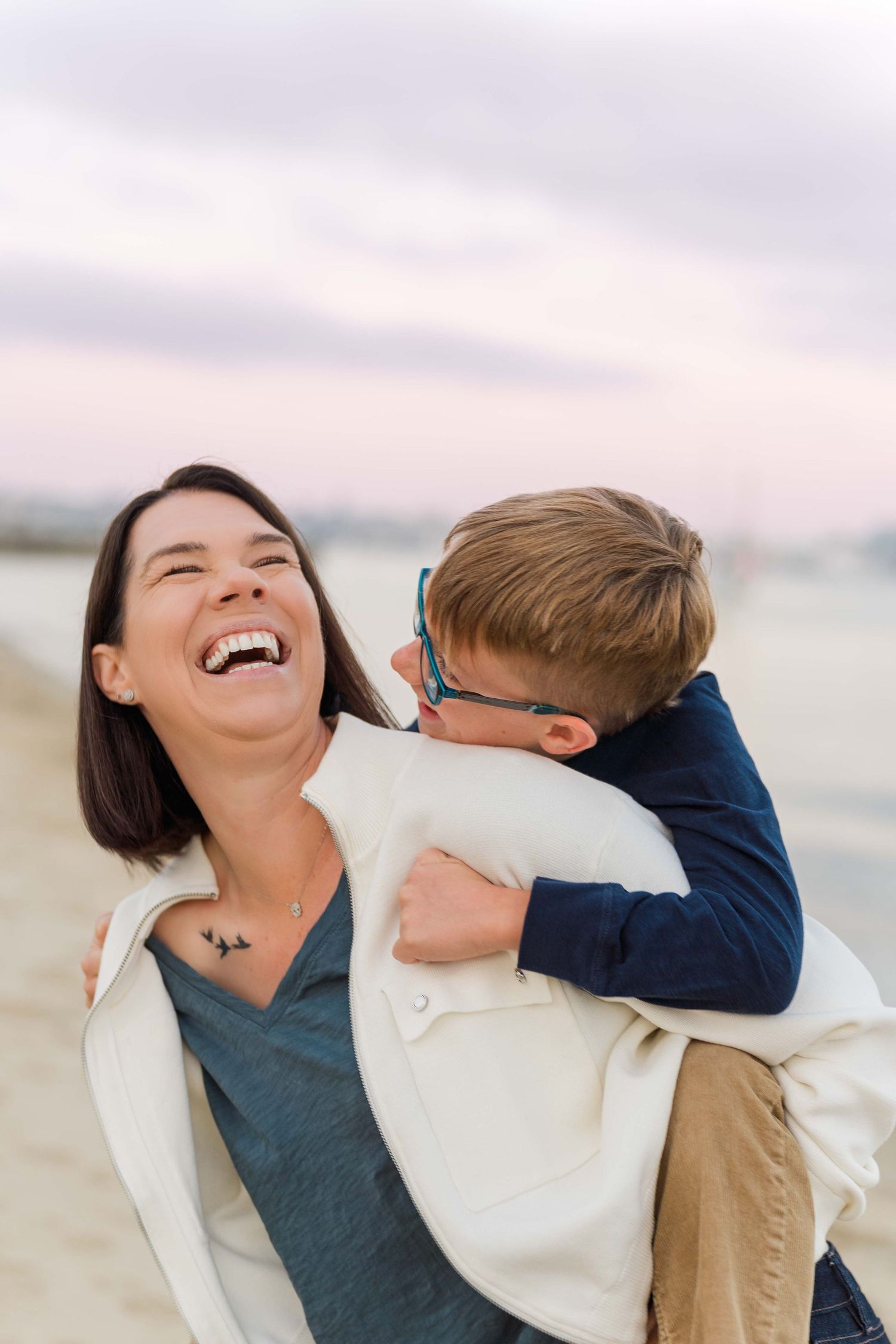 A joyful moment captured at the beach with laughter and embraces.