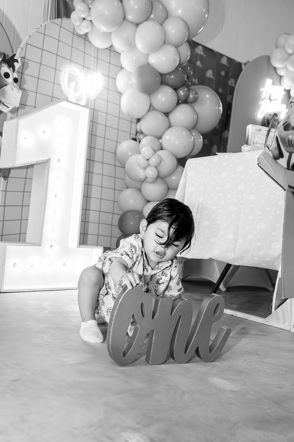 Black and white decorative sequence of images showing balloon arches and cursive text against a light background.