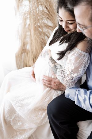 A romantic couple in formal attire embraces tenderly in a series of intimate portrait photos.