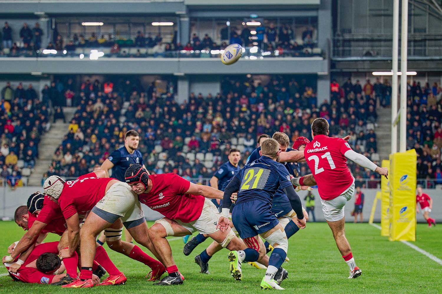 Rugby players from opposing teams engaged in a intense scrum formation during a match.