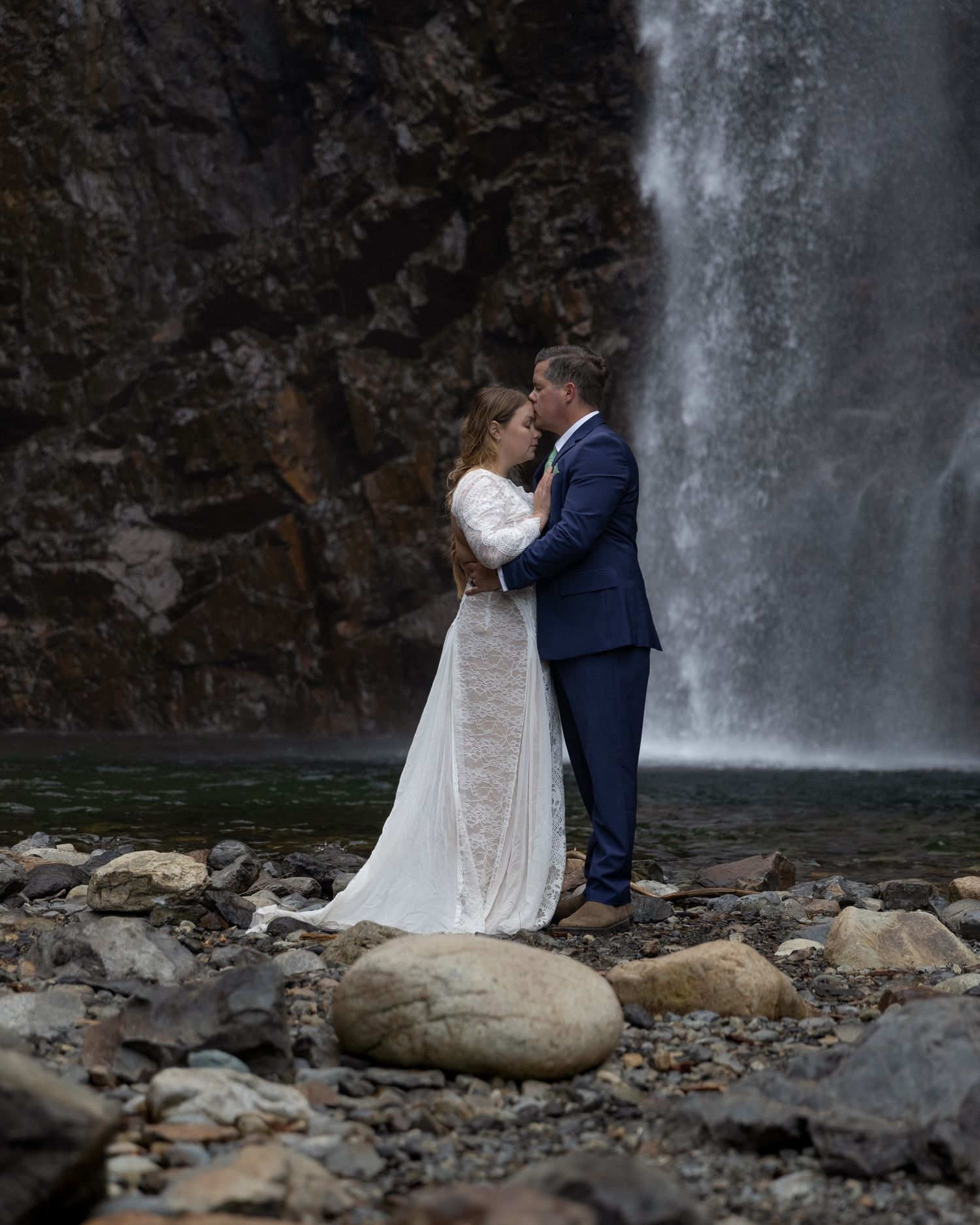 Charlie kisses Erin's forehead in front of Franklin Falls during their elopement near North Bend.