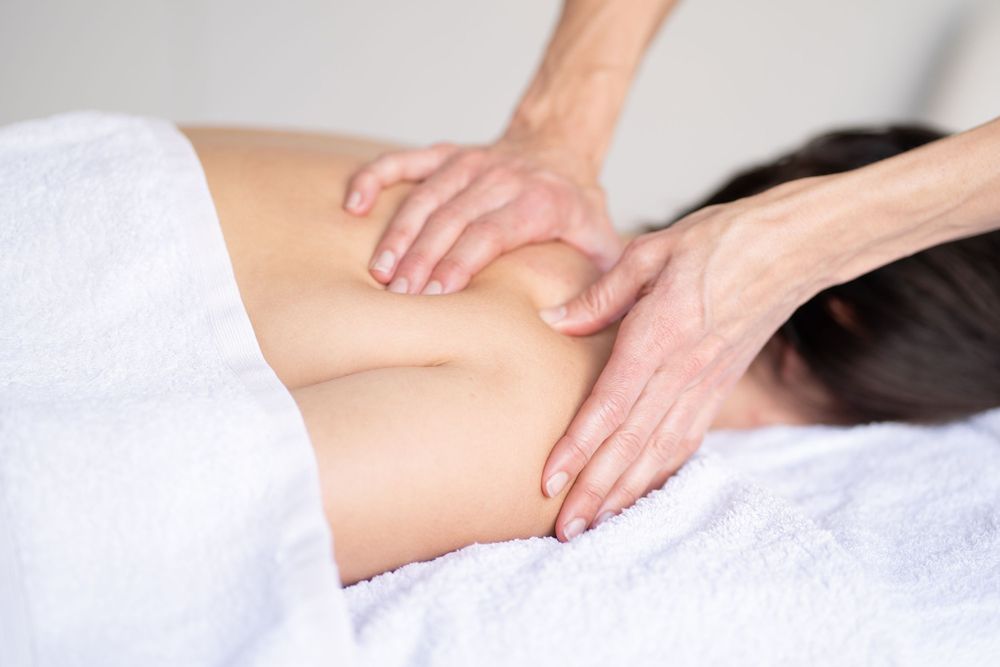 Close-up of therapeutic massage treatment on back with hands applying pressure.