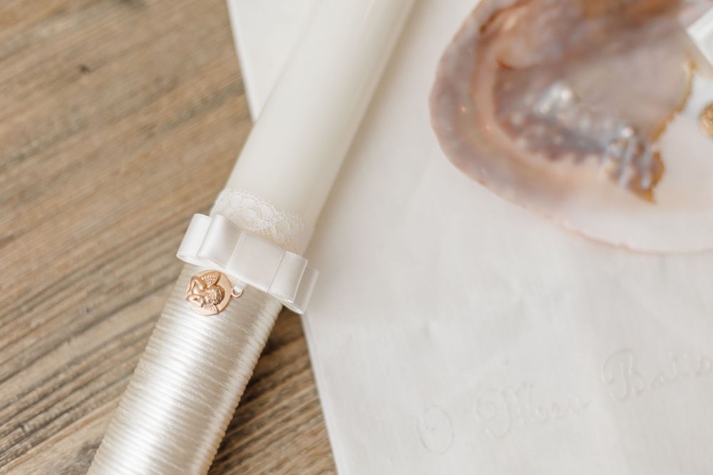 Close-up of an elegant silver-wrapped candle with a gold ring detail.