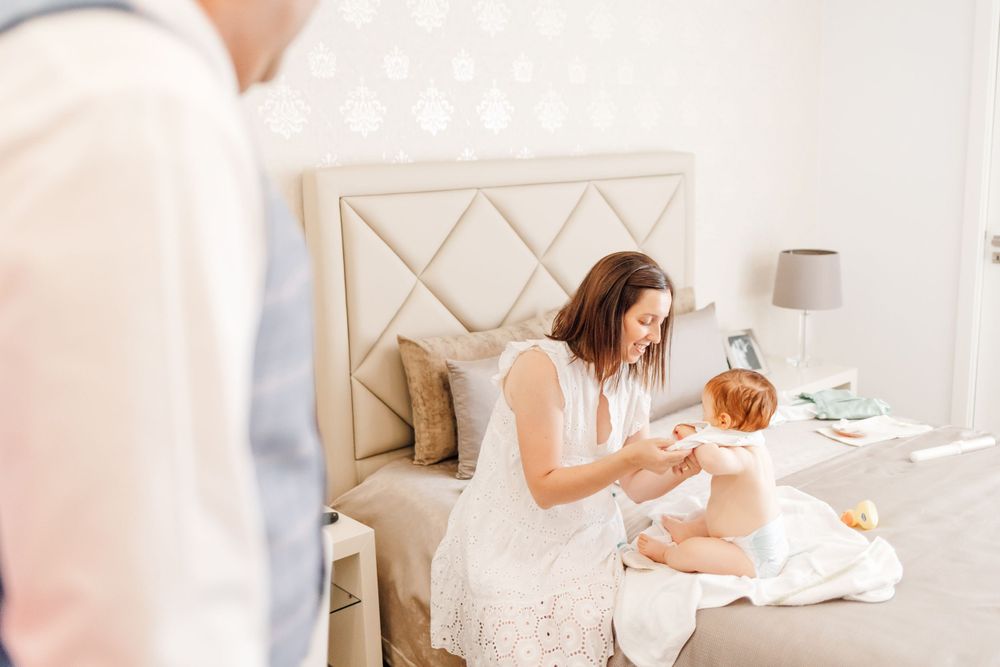 Interior bedroom scene showing tender morning moments with an infant.