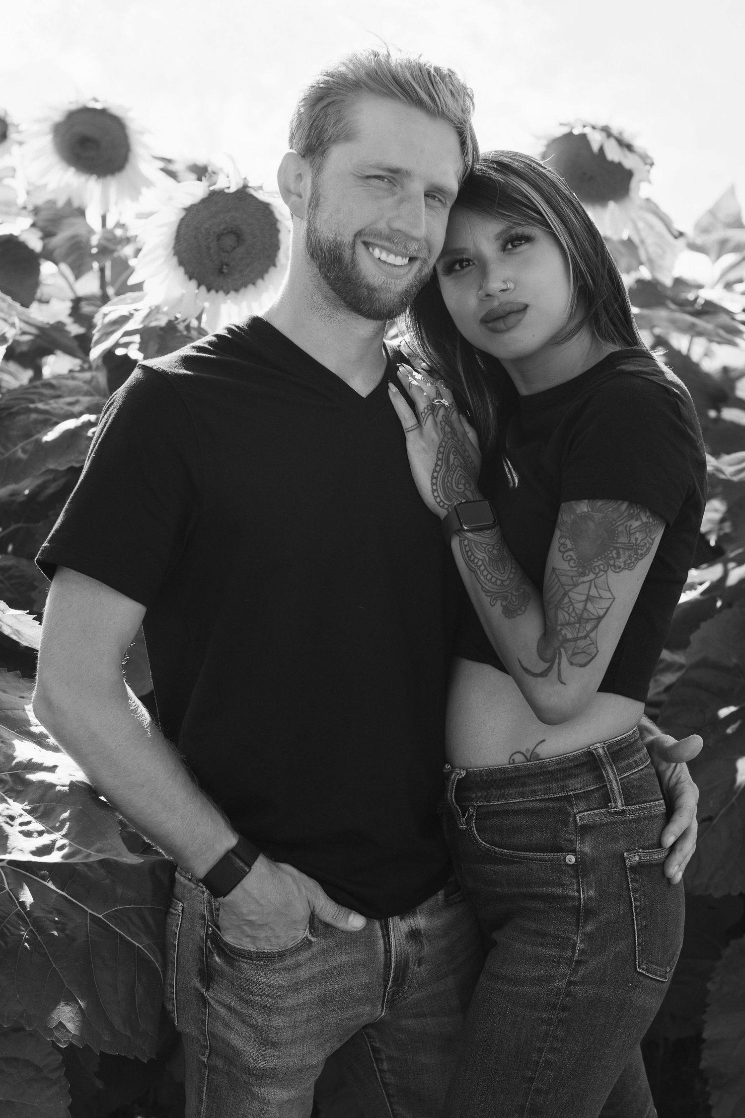 A black and white photo series showing a couple posing together in front of sunflowers during a romantic photoshoot.