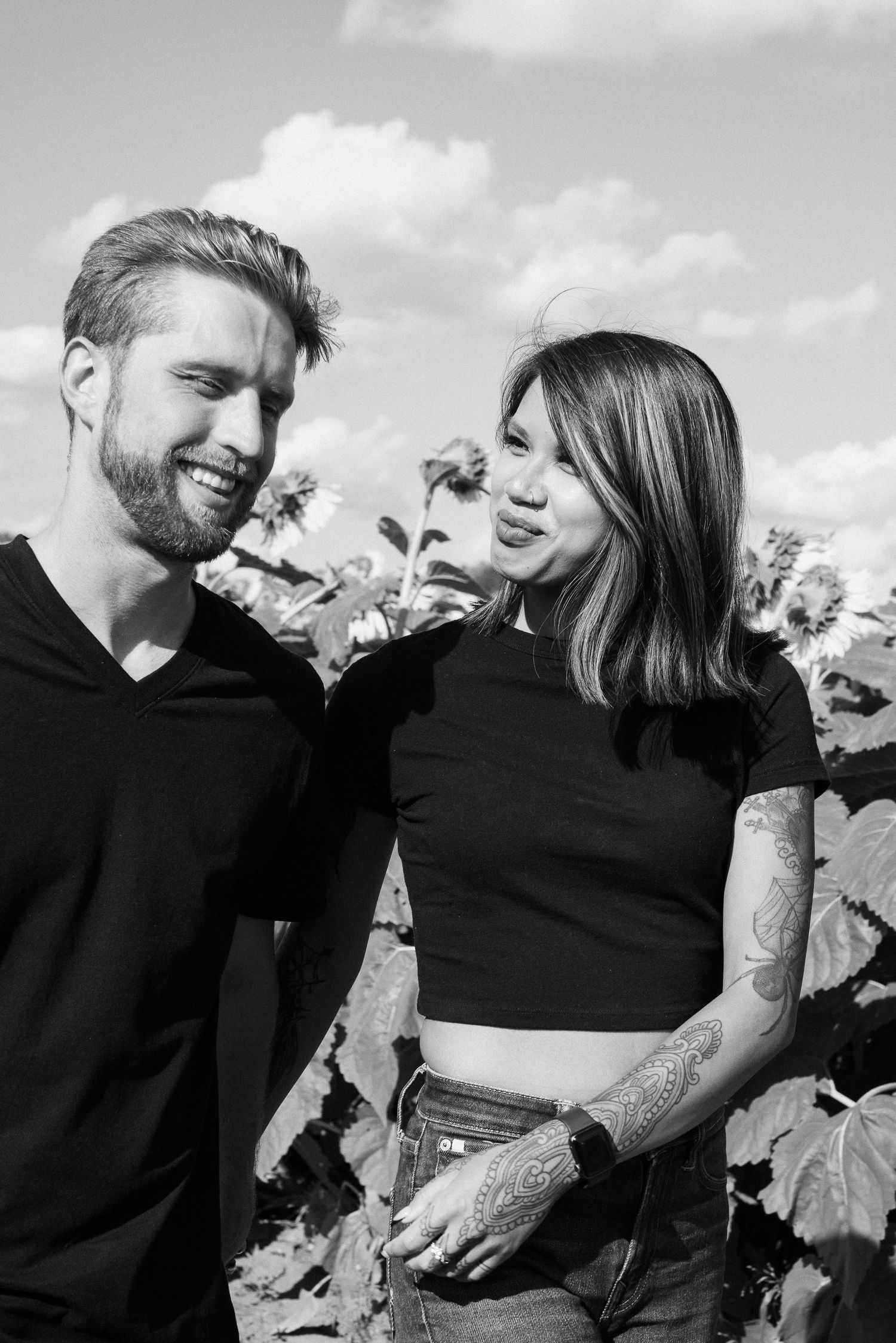 A couple shares joyful moments together in a black and white photo series among sunflowers.
