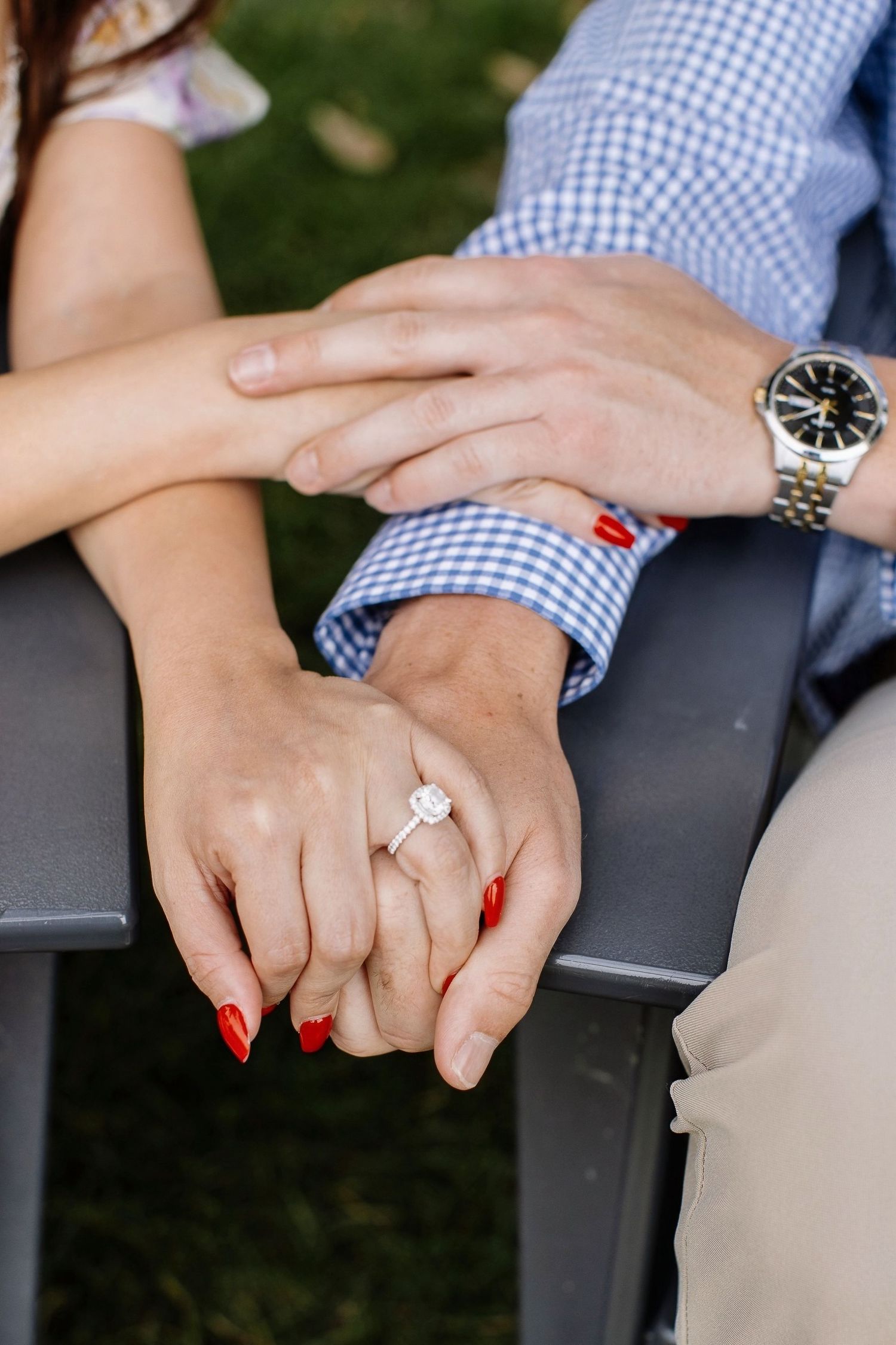 Close-up sequence showing hands with red nails and an engagement ring clasped together.