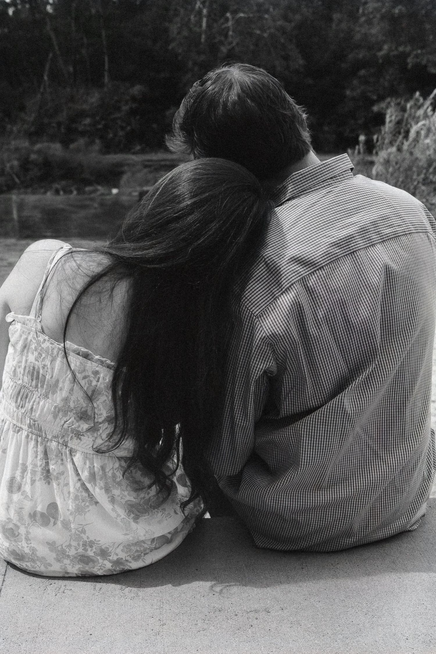 Black and white silhouettes of a couple lying down together in a romantic pose.