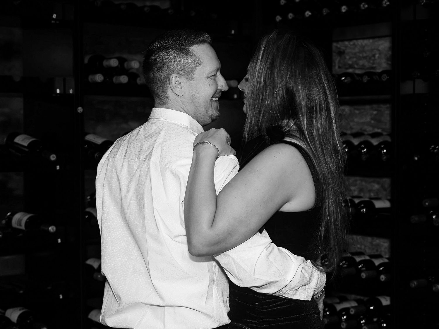Couples dancing together in an intimate black and white scene at an evening celebration.
