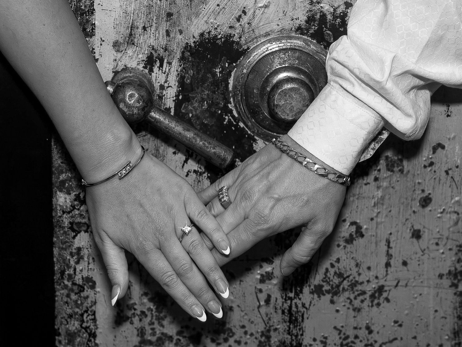 Close-up shot of hands displaying an engagement ring against a textured background.