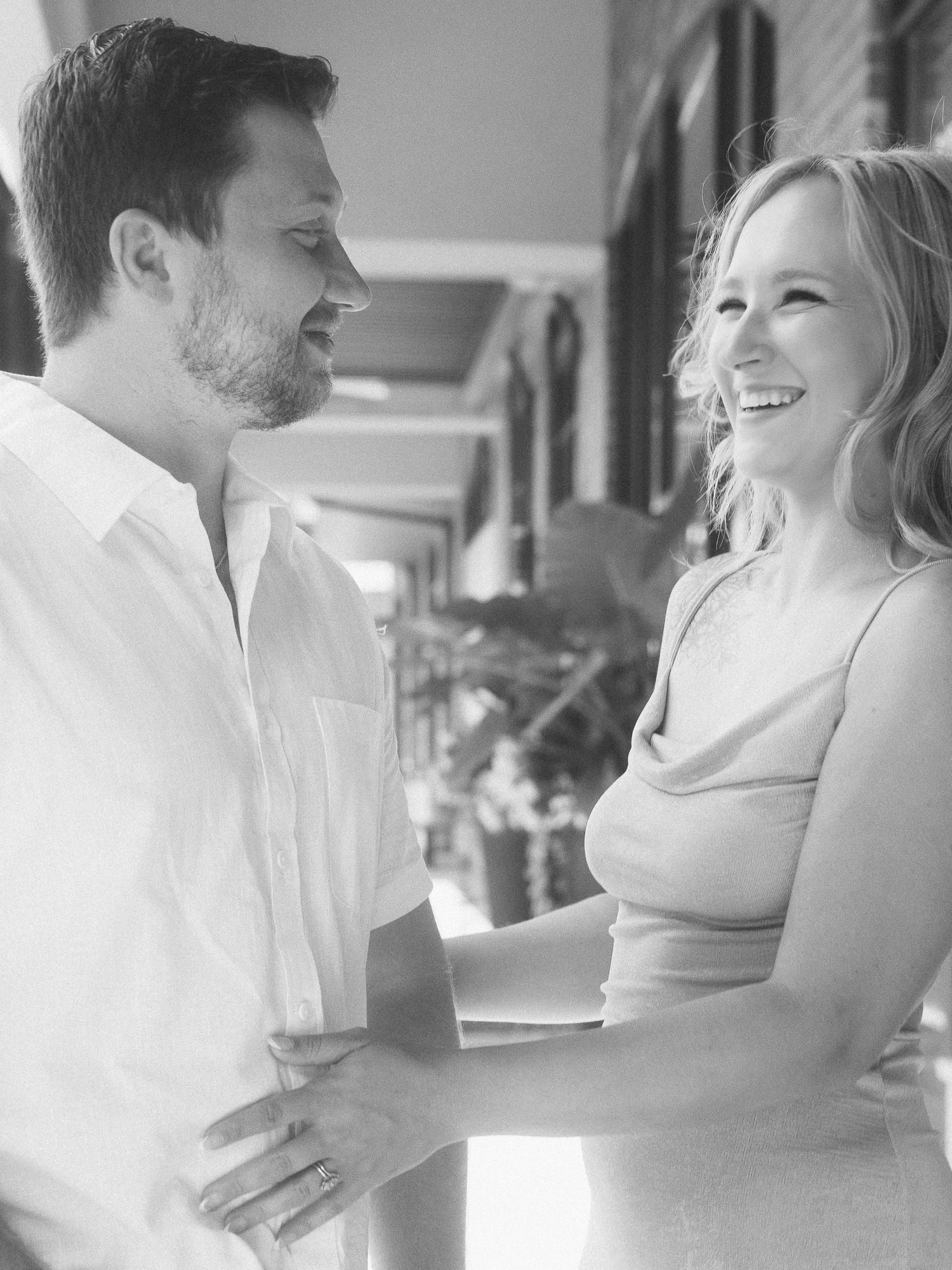 A romantic black and white sequence of a couple embracing and sharing intimate moments at an indoor venue.